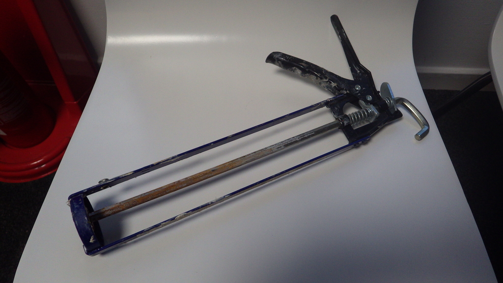 Caulking gun with open barrel